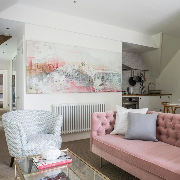 rengör och ta bort damm från vackert vardagsrum med rosa soffa och stor bild ovanför radiatorer