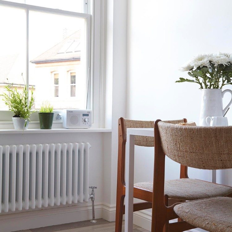 Rengör ett mysigt vardagsrum och värmare målade i vitt och håll det rent för bättre värmeeffekt