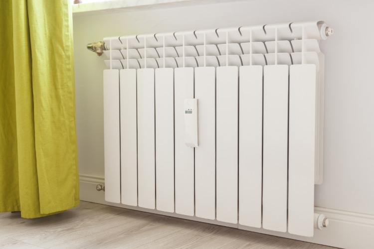 moderna radiatorer i vardagsrummet ser rena och välskötta ut efter underhåll och rengöring