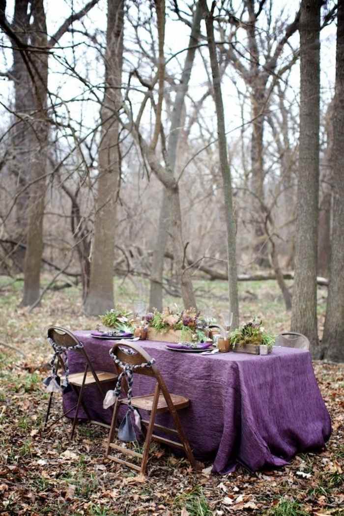 skog-bröllop-bord-hopfällnings-stolar-lila-färgade-duk-blomsterarrangemang