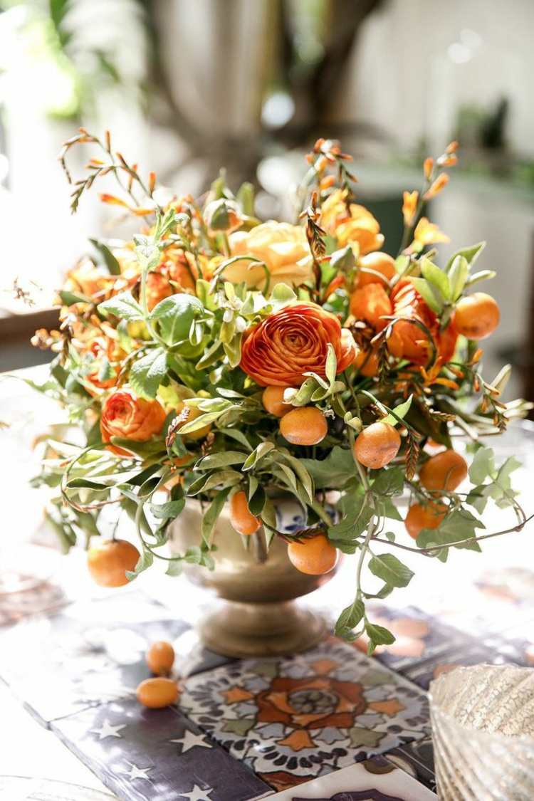 höstbordsdekoration med blommor orange höstfärg metallvas