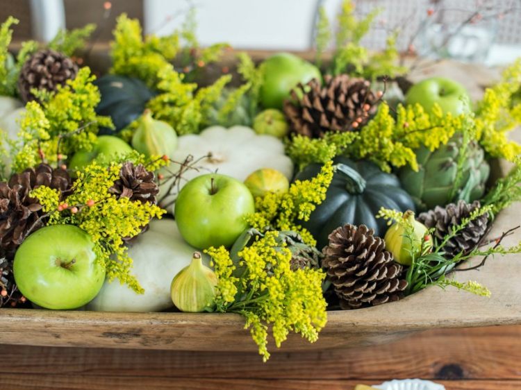 höstdekoration med pumpor grönt arrangemang natur äpplen gran kottar