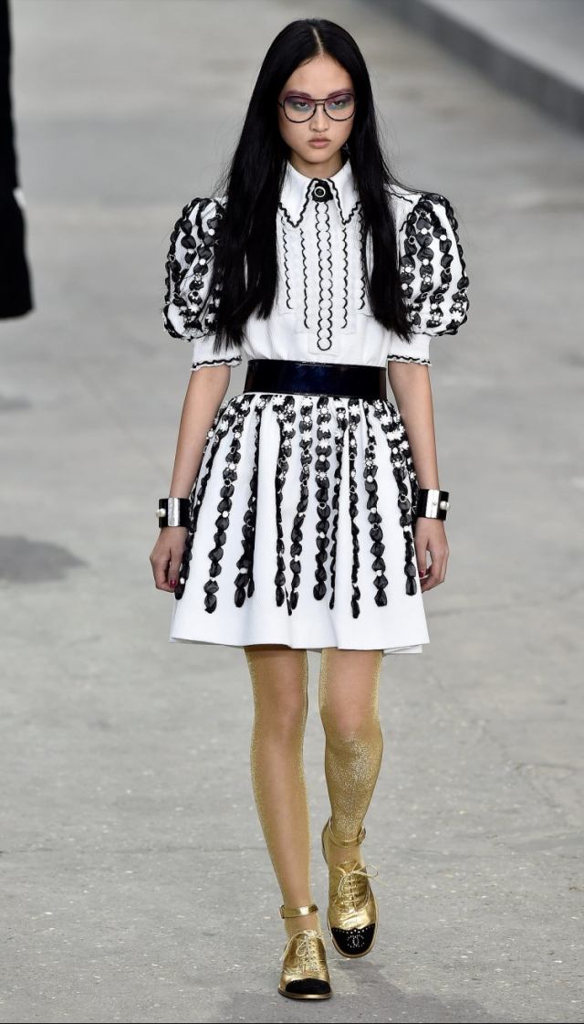 pariser-mode-vecka-2015-chanel-accessoarer-gyllene-platta-skor-armband-vit-klänning