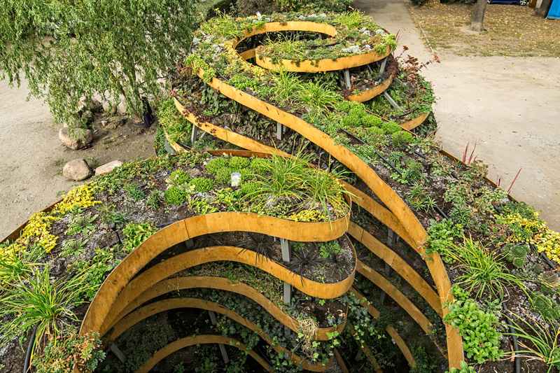 Upphöjd säng i trädgården som liknar oändlighetstecken-ört-spiral