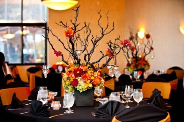 Bordsdekoration-svart-tak-med-orange-stolar-grenar av växter