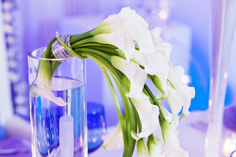 bröllopsplanering-isdrottning-blommig-dekorationer-liljor-vit-färg-blå-bakgrund