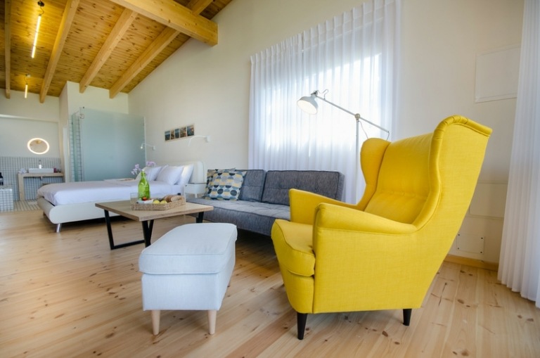 trägolv tak vardagsrum fåtölj gul pall vit modern