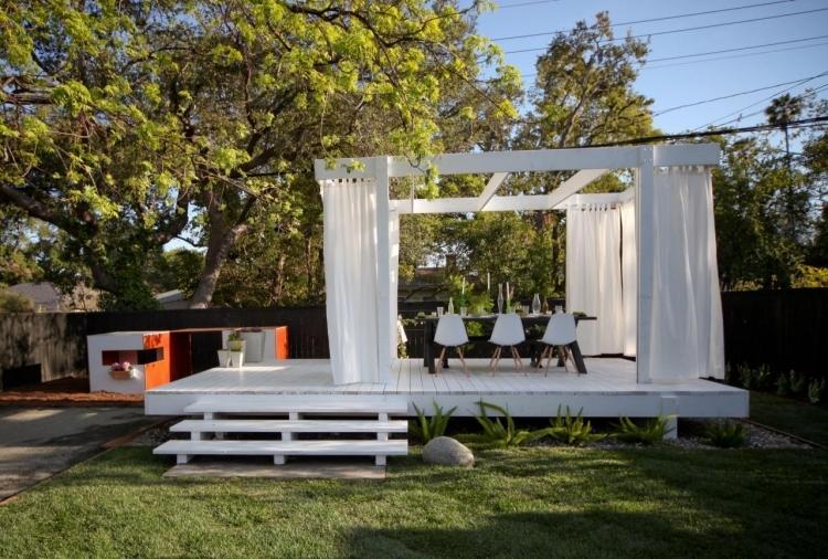 Träpergola-gardiner-vita-matbord-stolar-trädgård-gräsmatta-träd-vackra