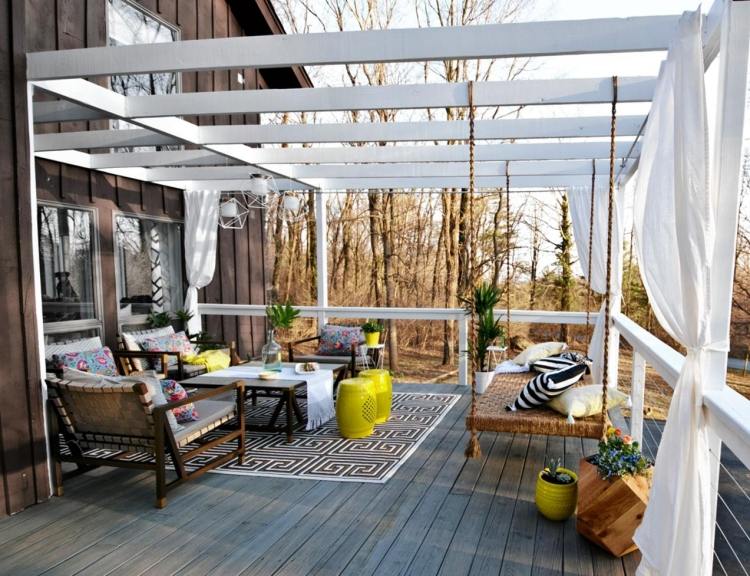 Träpergola-gardiner-vit-hängande säng-dagbädd-jute rep-trädgårdsmöbler-kuddar-pall-accenter-gul