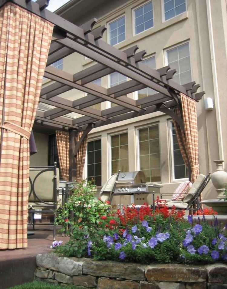 trä-pergola-gardiner-trädgård-grill-blommor-växter-tyg-randig-fönster-trädgårdsmöbler