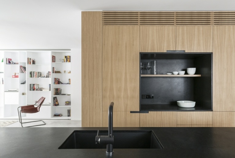 Minimalistiska högskåp av trä med en nisch i svart i köket