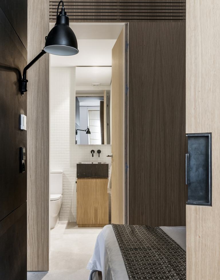 En träskiva med inbyggd dörr skiljer gästrummet från gästtoaletten och badrummet