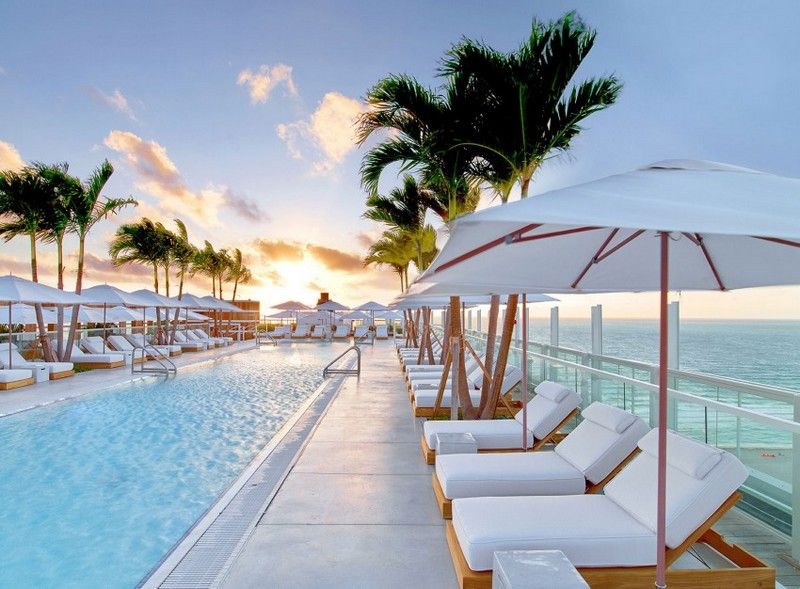 Trä och vitt design-strandhotell-terrass-pool-solstolar-vita parasoller
