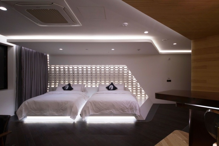 hotellrumsdesign med indirekt belysning träbeklädnad golv svart