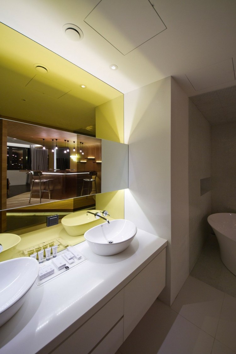 hotellrumsdesign indirekt belysning badrum vit gul konsolspegel