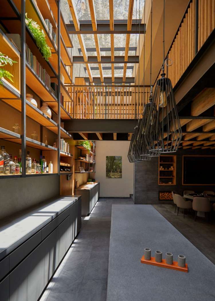 långt betongbord korsar ett modernt designat rum med hängande lampor i industriell stil
