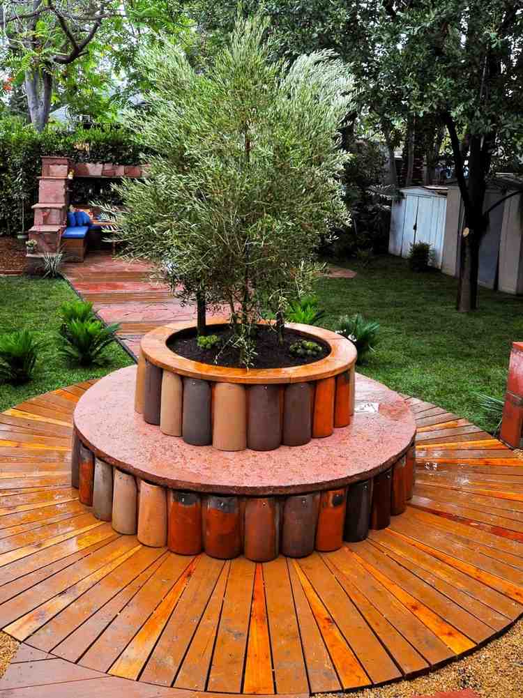 Bakgård med en rund träbänk och idéer gjorda av gamla takpannor för beläggning som kontaktpunkt i trädgården