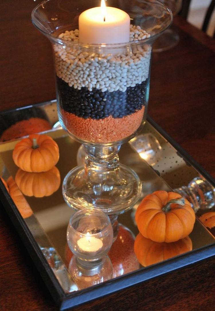 Hjärtat i höstens bordsdekoration: glas-lykta-huelsenfruechte-spegel-ljus-mini-pumpa
