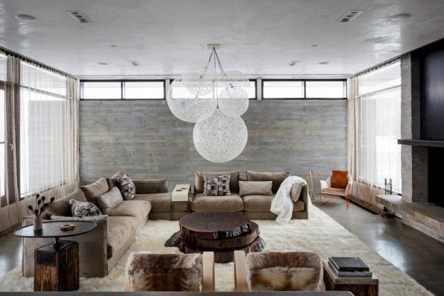 Vardagsrum betongvägg sidobord soffbord massivt trä eleganta lampor