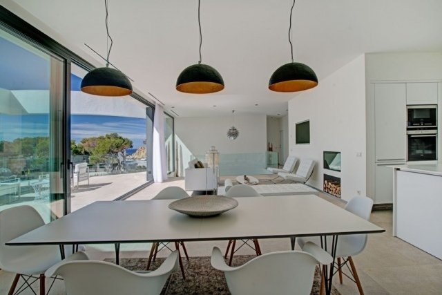 Möblerad villa med exotisk touch av vita möbler-utrustade kök-matplats med ljus