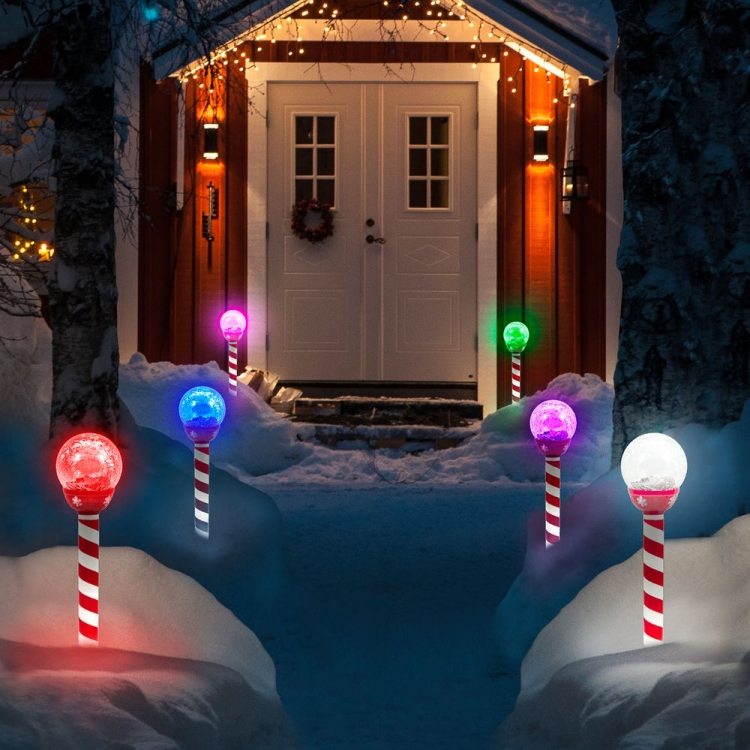 Juldekoration utanför-upplyst-ytterdörr-vit-röd-godis-käppar-pollare ljus-färgade-snö-