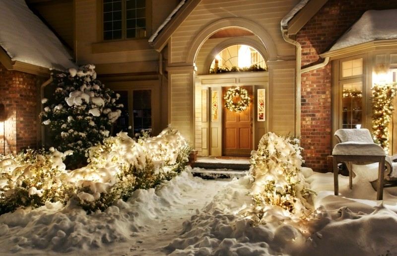 juldekoration utanför upplyst-ytterdörr-hus-snö-tegel-vackra-riktiga buskljus