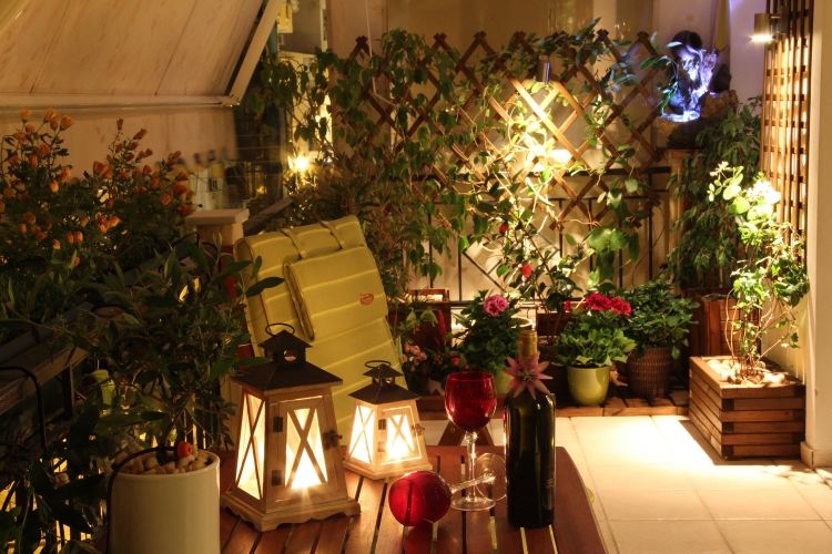 design-terrass-country-stil-ljus-lyktor-romantiska-växter-blommor-vin-växt krukor