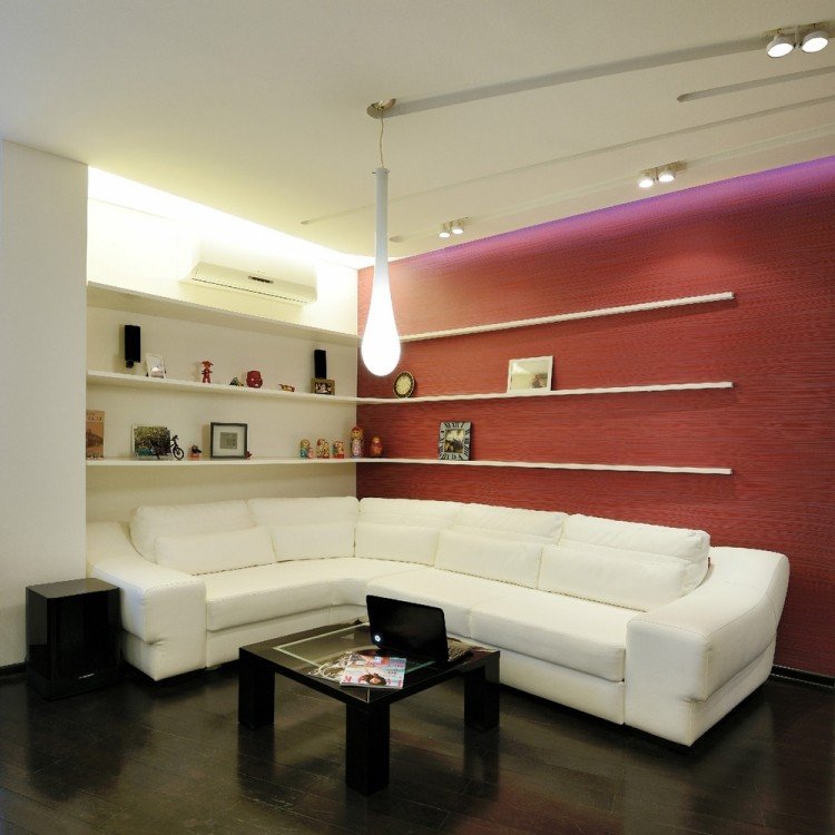 vardagsrumsmöbler-idéer-modern-indirekt-led-tak-belysning-hörn-hyllor-vit-soffa-röd-accentvägg