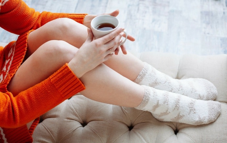 immunförsvar-stärka-kvinna-dricka-te-frisk-tröja-soffa-strumpor-varma-fluffiga fötter