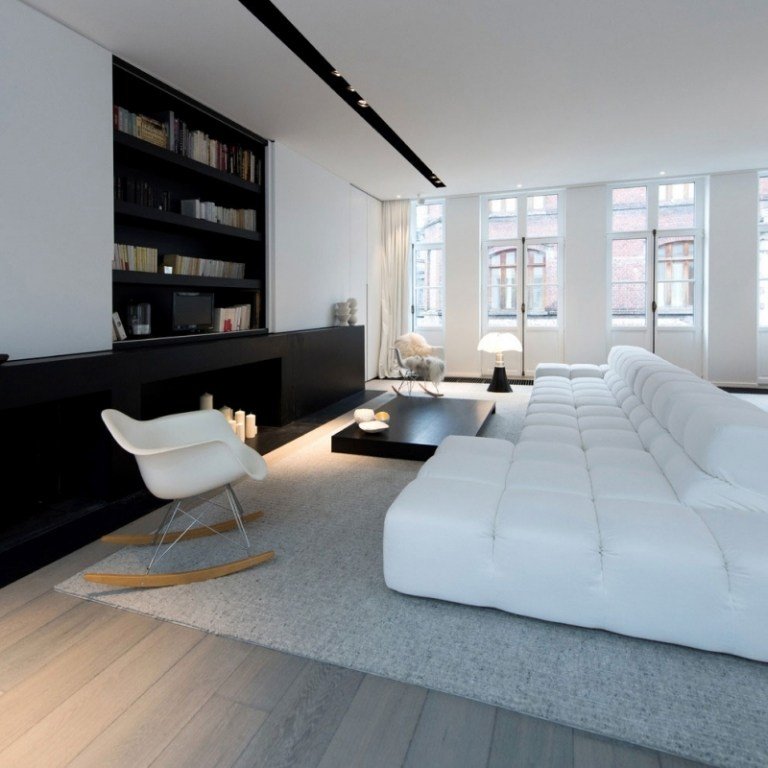 Svartvitt inredning-lägenhet-lyx-modernt-vardagsrum-modul-soffa-matta-grå-dekorativa-eldstad-ljus