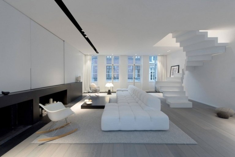Svartvitt inredning-lägenhet-lyx-vardagsrum-spiraltrappa-modulär-soffa-öppen spis-dekorativ-inmurad