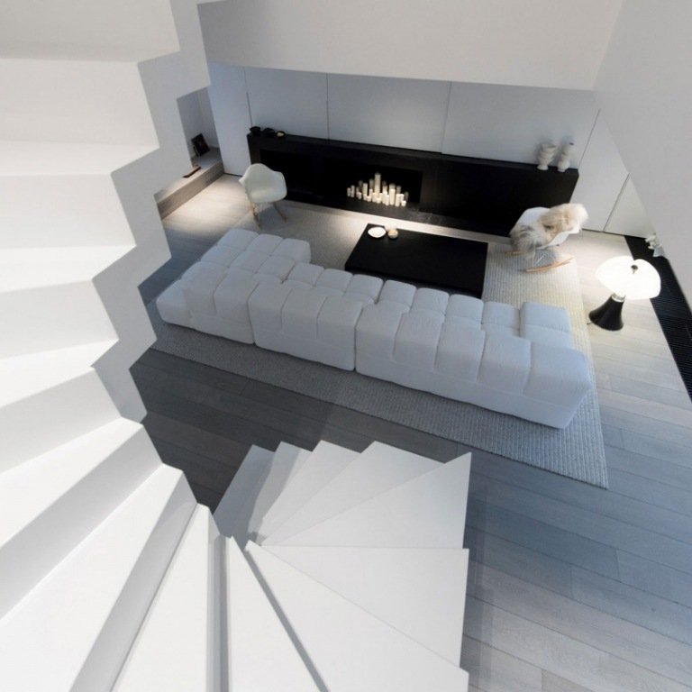 Svartvitt inredning-lägenhet-mansard-spiraltrappa-vardagsrum-soffa-matta-golv-grå