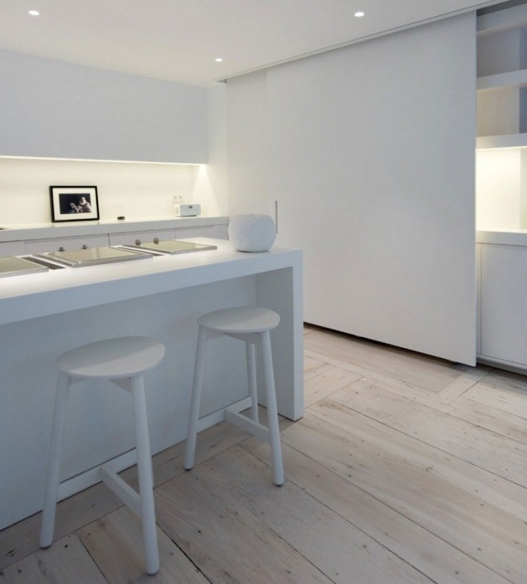svart-vit-möblerad-lägenhet-minimalistiska-fläckar-köksbänk-pall-fläckar-golvbräda-skjutdörr