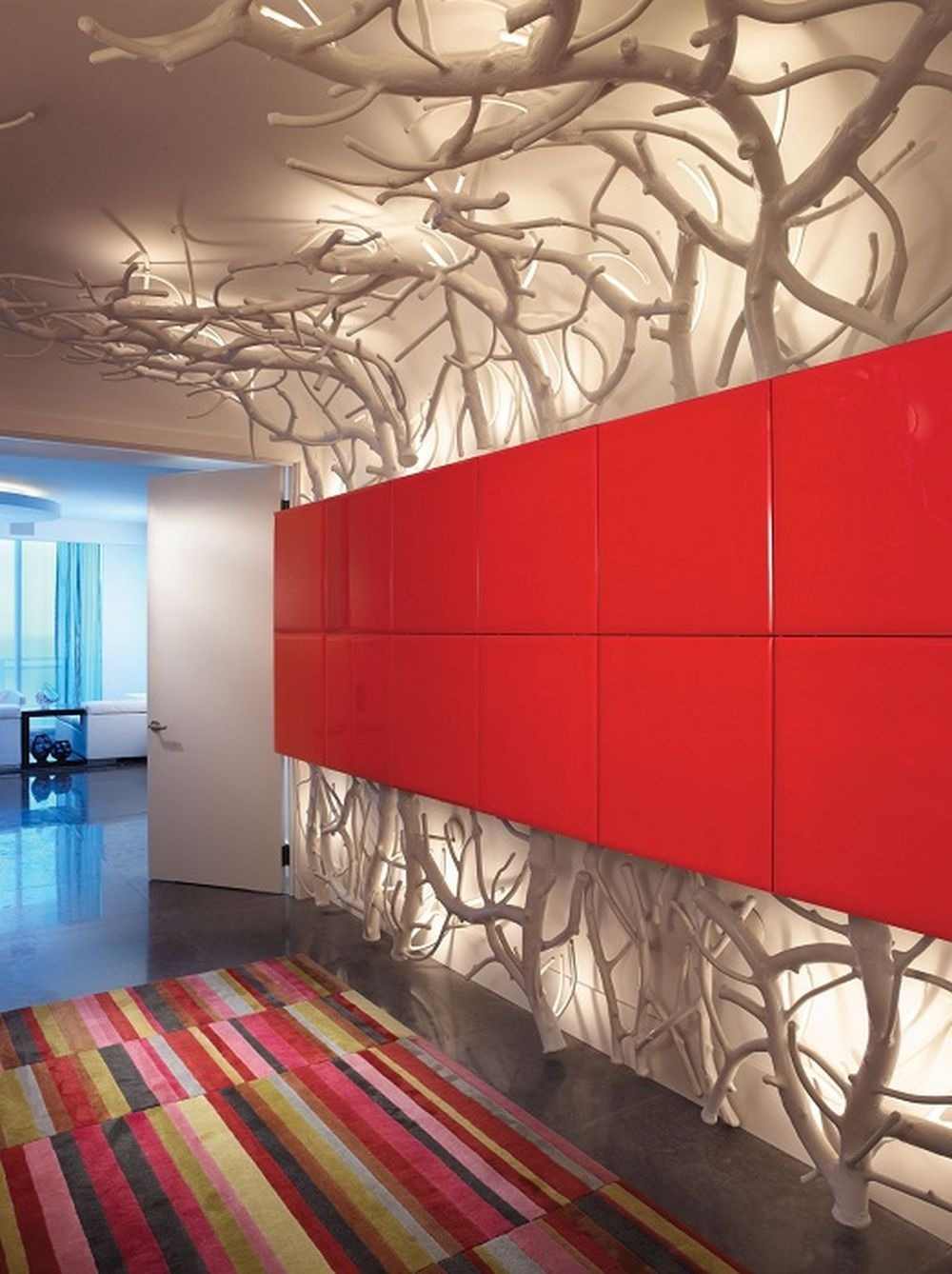 konstnärlig design och indirekt belysning i korridoren bakom röda väggpaneler och grenar