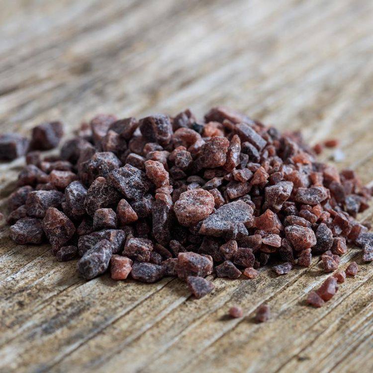 indiskt svart salt kala namak friskt köp hawaii kristaller brun rödaktig trä yta närbild