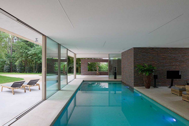 Inomhus-pool-bygg-glas-skjutdörr-trädgård-utsikt