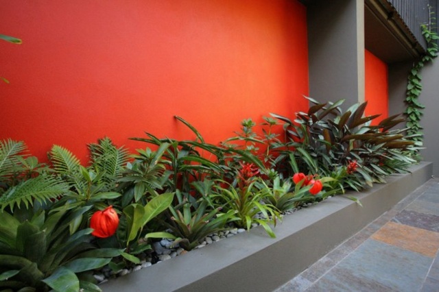 Blomrabatter innergård vägg betong orange färg