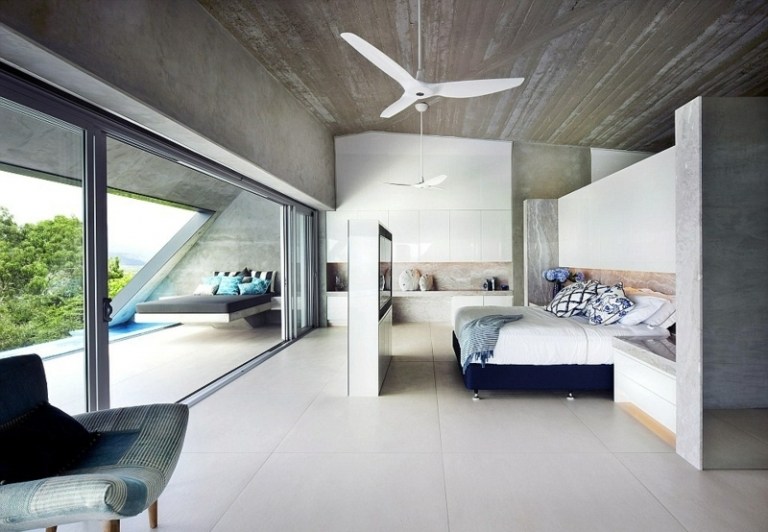 betong och granit interiör sovrum partition tv säng blå