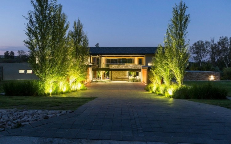hus naturmaterial modern rustik stil träd häckar belysning