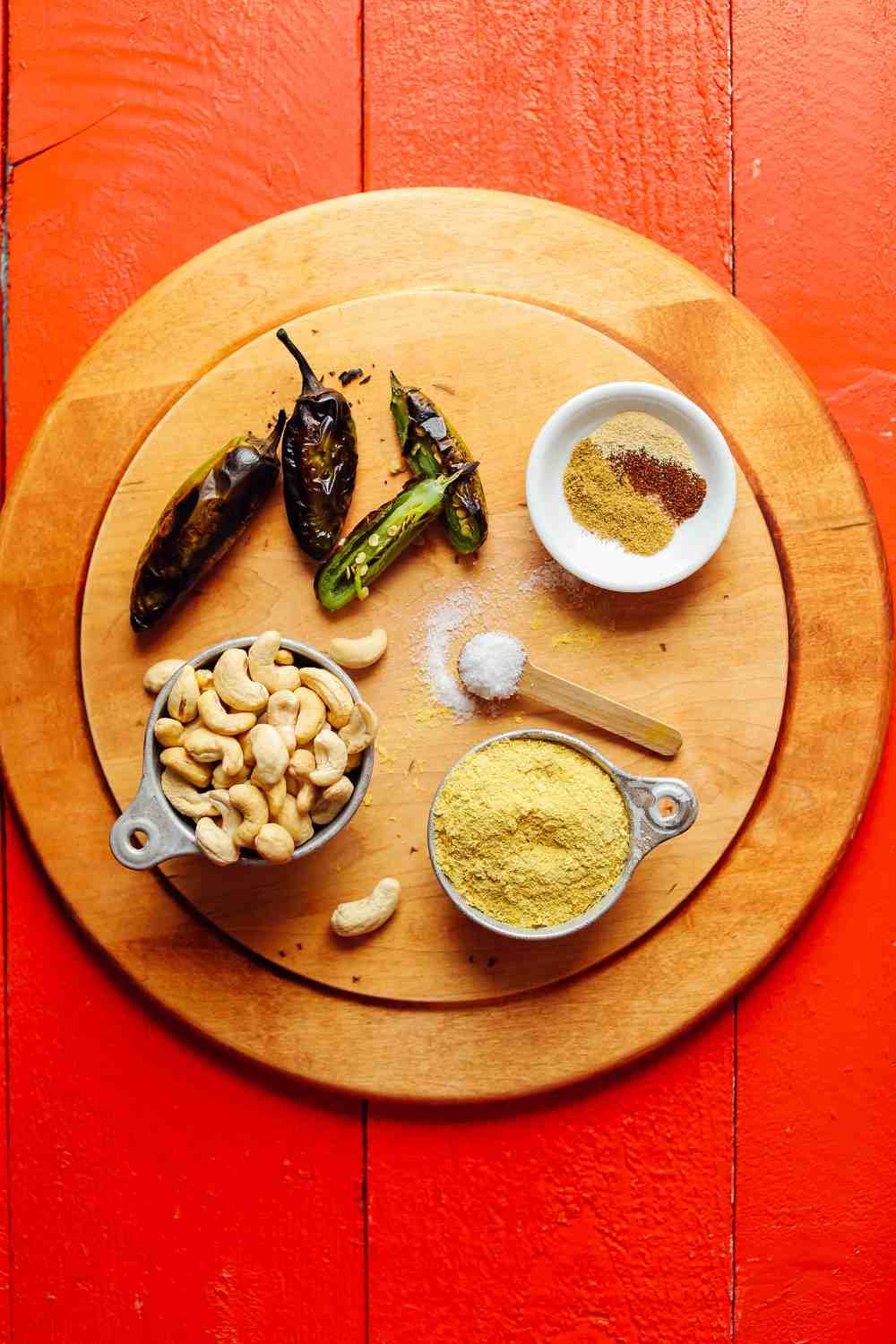 Rostade jalapenos med kryddor och cashewnötter på en roterande tallrik i trä