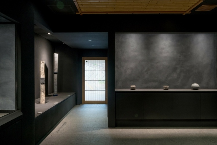 interiör kondo museum japan dämpad belysning sten grå trä