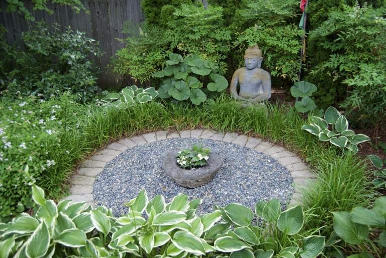 japansk trädgård runt stenväxter buddha staty