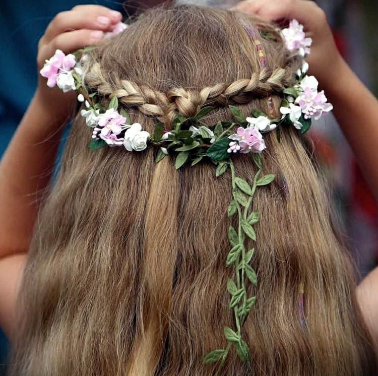 Halvöppen frisyr med en krans av blommor för en feminin och söt look