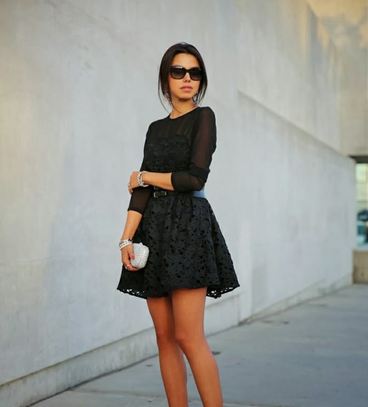 Elegant i svart med en långärmad klänning i tyll och spets och med en handväska