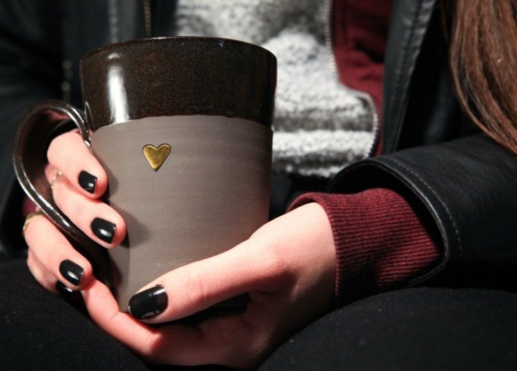 ta bort kaffefläckar tjej-kaffemugg-svart-hjärta-håll-brun-guld-utsida-jacka-tröja