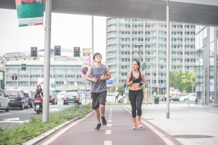ungt par som joggar i staden kan effektivt bränna fler kalorier genom träning och intensitet