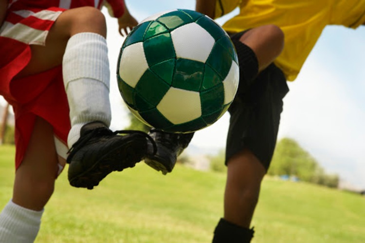 Unga fotbollsspelare på fotbollsplan duell för bollen
