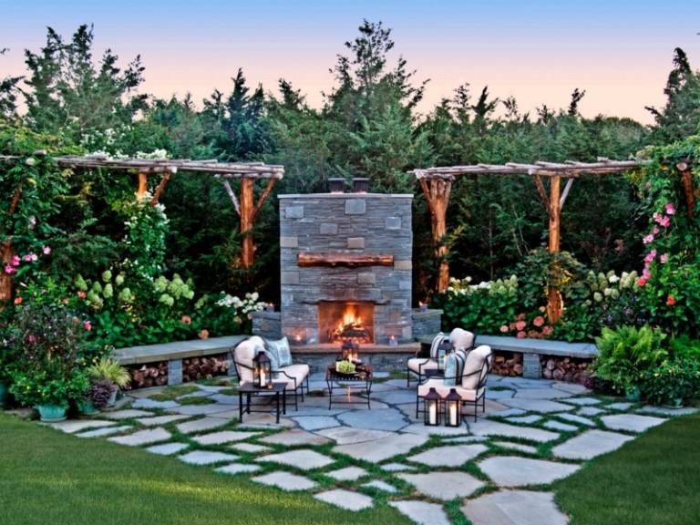 öppen spis i trädgården romantiska växter pergola stolar metall stenplattor