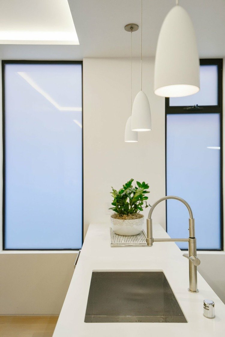 minimalistiskt kök i vita hängande lampor rena bänkskivor