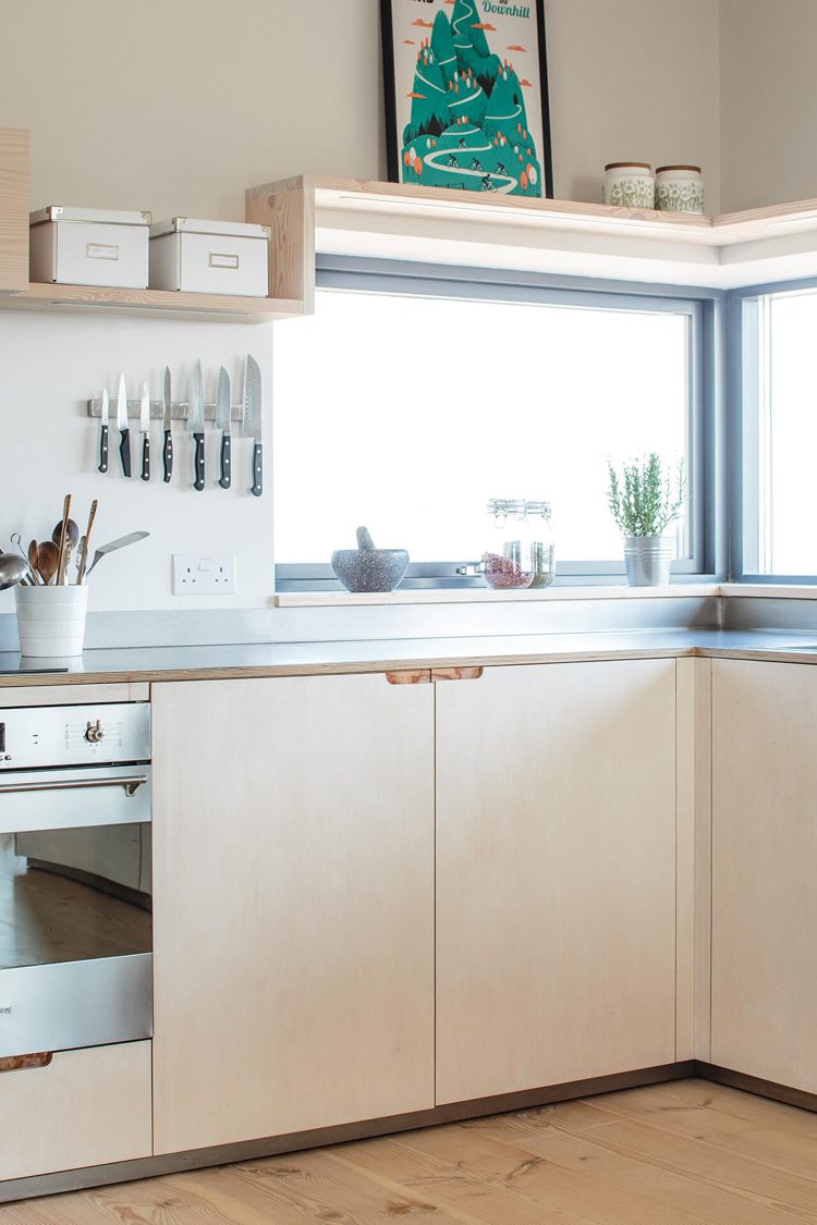 Designa köket med ett fönster tvärs över hörnet med en fönsterbräda och hyllor